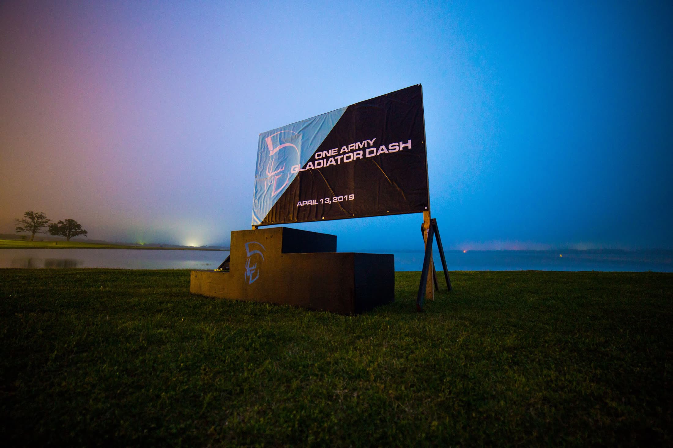 The Gladiator Dash banner standing at the water's edge at Lake Bryan before dawn